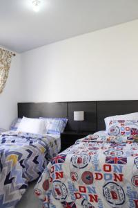 dwa łóżka siedzące obok siebie w sypialni w obiekcie Residencial Privada Nueva San miguel, casa Flores w mieście San Miguel