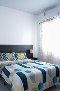a bedroom with a bed and a window at Casa flores Residencial Privada Nueva San miguel in San Miguel