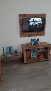 a living room with a tv and two tables at Chalés Manacá da Serra in Ubatuba