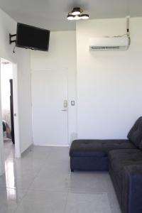 a living room with a couch and a flat screen tv at Residencial Privada Nueva San miguel, casa Flores in San Miguel