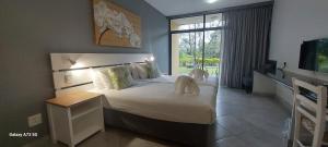 a bedroom with a large bed and a large window at Elephant Lake Hotel in St Lucia