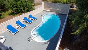 - une vue sur la piscine et ses chaises longues bleues dans l'établissement Oceanside, Hot Tub, Private Pool, OS1B, Always Unforgettable, à Corolla