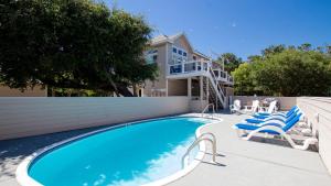 une piscine avec des chaises longues et une maison dans l'établissement Oceanside, Hot Tub, Private Pool, OS1B, Always Unforgettable, à Corolla