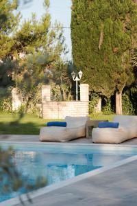 a group of pillows sitting next to a swimming pool at The Green House Villa (with private pool) Corfu in Sidari