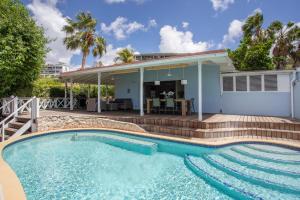 a swimming pool in front of a house at Villa Mai Blu in Willemstad