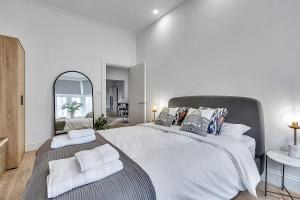 1 dormitorio blanco con 1 cama grande y espejo en The Pembroke en Londres