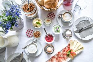 维皮泰诺Rieplhof - Relaxing farm stay with breakfast and mountain view的一张带食物盘和咖啡杯的白色桌子