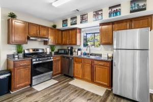 a kitchen with wooden cabinets and a stainless steel refrigerator at Home away from home! Min from the airport and downtown in Atlanta