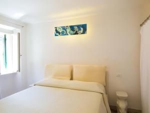 a bedroom with a bed with white sheets at Appartamenti Dietro L'Angolo in Portoferraio