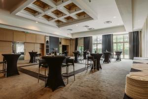 a large room with tables and chairs and windows at Serwir Hotel in Sint-Niklaas