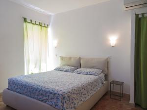 een slaapkamer met een bed met een blauw dekbed en een raam bij Appartamenti Dietro L'Angolo in Portoferraio