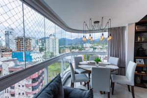 comedor con mesa y ventana grande en Nilmare Apartamentos e Suites para suas Férias, en Itapema