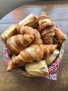 a basket of croissants and bread on a table at Cornerways B&B in Chipping Campden