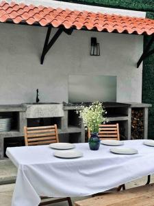 una mesa con platos y un jarrón de flores. en Casa Cantera, en Teziutlán