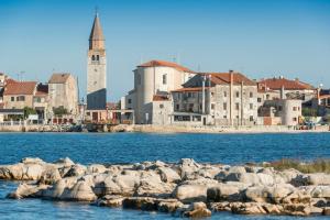 Un gruppo di rocce nell'acqua vicino a una città di Garden Palace Pool Deluxe Apartment a Umag (Umago)