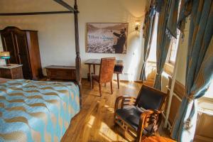 a bedroom with a bed and a table and a chair at Hotel & Tagungszentrum Schloss Hohenfels in Hohenfels