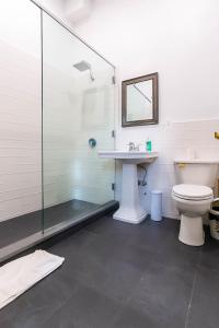 uma casa de banho com um chuveiro, um WC e um lavatório. em NY Moore Hostel em Brooklyn