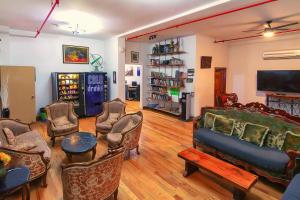 uma sala de estar com um sofá e cadeiras e uma televisão em NY Moore Hostel em Brooklyn