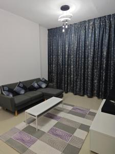 a living room with a couch and a table at Pearl Apartment in Ajman 