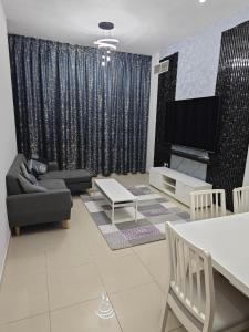 a living room with a couch and a tv at Pearl Apartment in Ajman 
