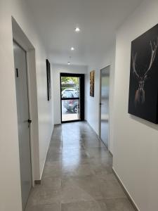 un couloir d'une maison avec des murs blancs et une hallwayngth dans l'établissement Résidence République, à Dijon