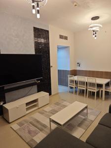 a living room with a large flat screen tv at Pearl Apartment in Ajman 