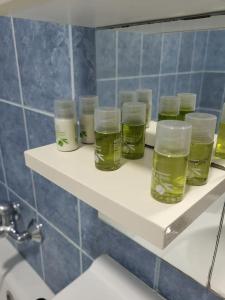 a shelf with four glasses on it in a bathroom at Wishy Washy House in Debrecen