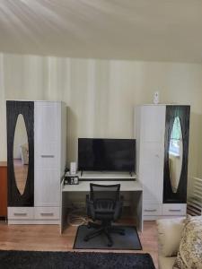 escritorio con ordenador y silla en una habitación en Wishy Washy House, en Debrecen