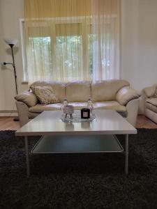 a white coffee table in a living room with a couch at Wishy Washy House in Debrecen +11 photos