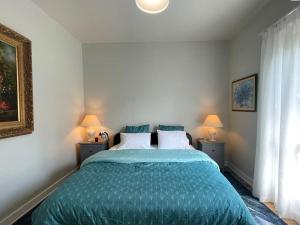 ein Schlafzimmer mit einem Bett mit einer grünen Bettdecke in der Unterkunft Kiki House-belle aire près de Paris in Antony