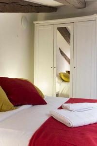 1 dormitorio con cama blanca con sábanas rojas y espejo en Cómodo Ático en Tirso de molina Madrid, en Madrid