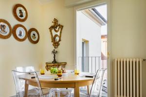 a dining room with a wooden table and chairs at GetTheKey Attico delle Torri in Bologna