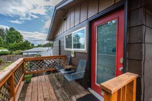 una terrazza con tavolo, sedie e porta rossa di Emerald City Studio Suite a Eugene