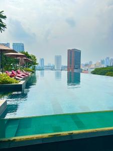 a large swimming pool with a view of a city at Grand Residence Suite At Opus Kuala Lumpur in Kuala Lumpur