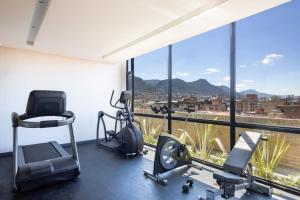 a gym with a large window with a view of a city at Cassa Luxury Homes in Bogotá