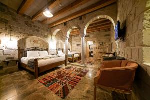 a bedroom with two beds and a stone wall at Caverna Hotel Premium Caves in Goreme