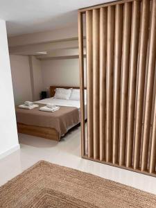 Schlafzimmer mit einem Bett und einer großen Glasschiebetür in der Unterkunft Minimal Cozy Apartment in Mytilini