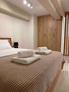a bedroom with two towels sitting on a bed at Minimal Cozy Apartment in Mytilini