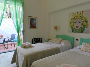 1 dormitorio con 2 camas y una estatua de una mujer en Stromboli Trekking Accommodation - Room and Excursion for 2 included, en Stromboli