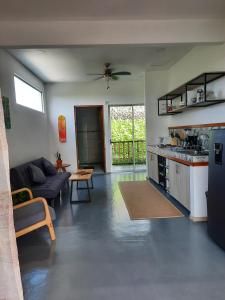 Una sala de estar con un sofá y una cocina. en Casa CIELO, en Santa Teresa Beach 19 fotos más
