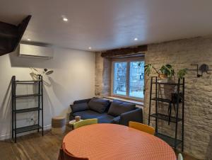 a living room with a couch and a table at Maison de Bourg Cressensac in Cressensac