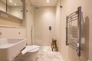 a white bathroom with a sink and a toilet at The Notting Hill Apartments By Hok Living - Nh1 in London