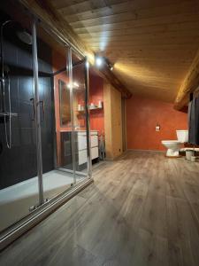 a large room with a shower and a wooden floor at Appartement Chalet Petzu - 6 Pers - Parking - Ski au pied in Levassaix