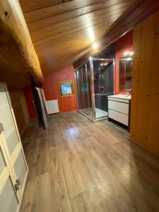 a large room with a wooden ceiling and a bathroom at Appartement Chalet Petzu - 6 Pers - Parking - Ski au pied in Levassaix