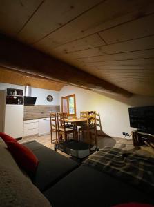 a living room with a couch and a table and chairs at Appartement Chalet Petzu - 6 Pers - Parking - Ski au pied in Levassaix