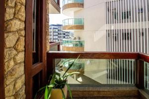 a balcony with a window and a potted plant at Belo apto c/ suíte 5 min da praia do Forte BFC301 in Cabo Frio