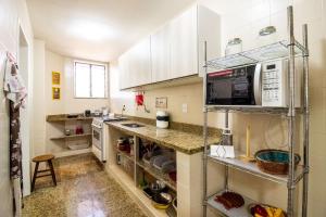 a kitchen with white cabinets and a counter at Belo apto c/ suíte 5 min da praia do Forte BFC301 in Cabo Frio