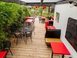 un patio con mesas, sillas y plantas en Hébergement Insolite Picasso, en Lanester