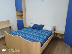 a small bed in a room with blue cabinets at La Casetta sul mare - Alloggio turistico in Fiumicino