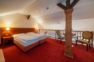 a bedroom with a bed and a wooden cross on a balcony at Hotel Raffaello Prague in Prague